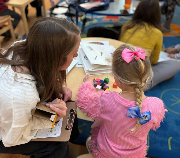 A pre-school age child speaks with her teacher at First Impressions.